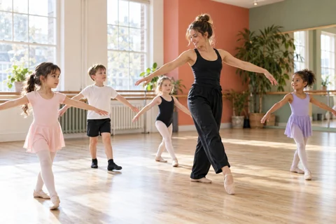 Dance teacher guiding children in a studio